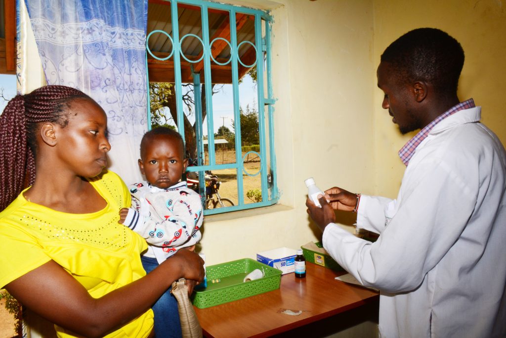 Noah Samoei assisting a patient at Kimuri Dispensary, Eldoret.